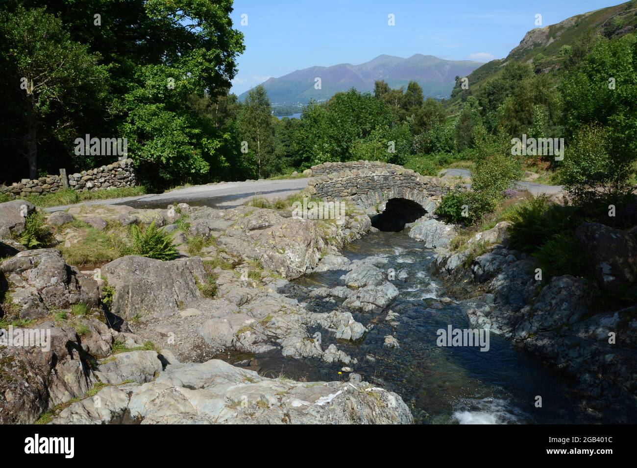 Vieux pont de pierre sur un ruisseau rocheux quelque part dans le district de lac de Cumbria en Angleterre. Banque D'Images