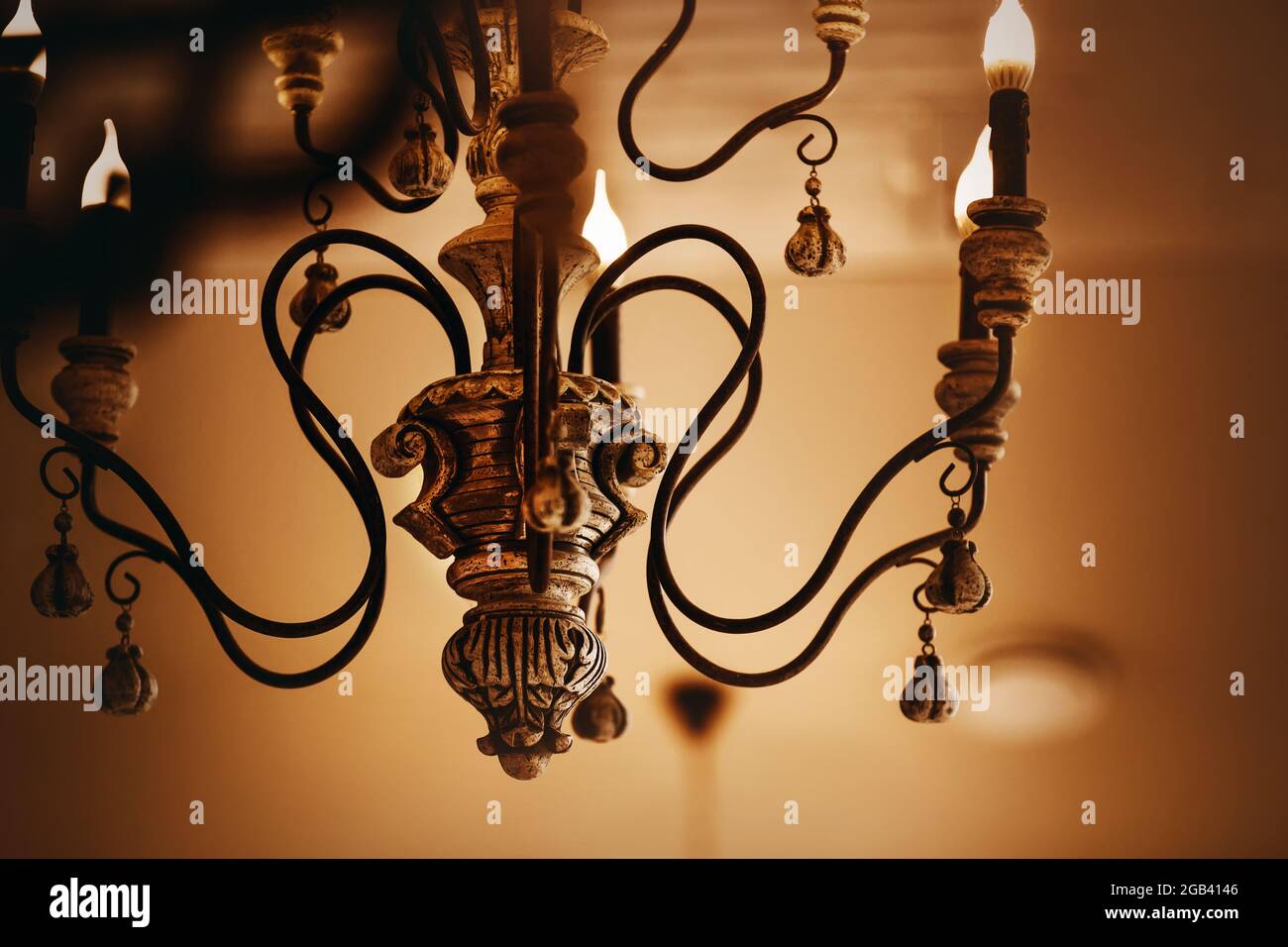 Un vieux lustre élégant et riche avec bougies électriques en chandeliers brille la nuit. Richesse et beauté. Banque D'Images