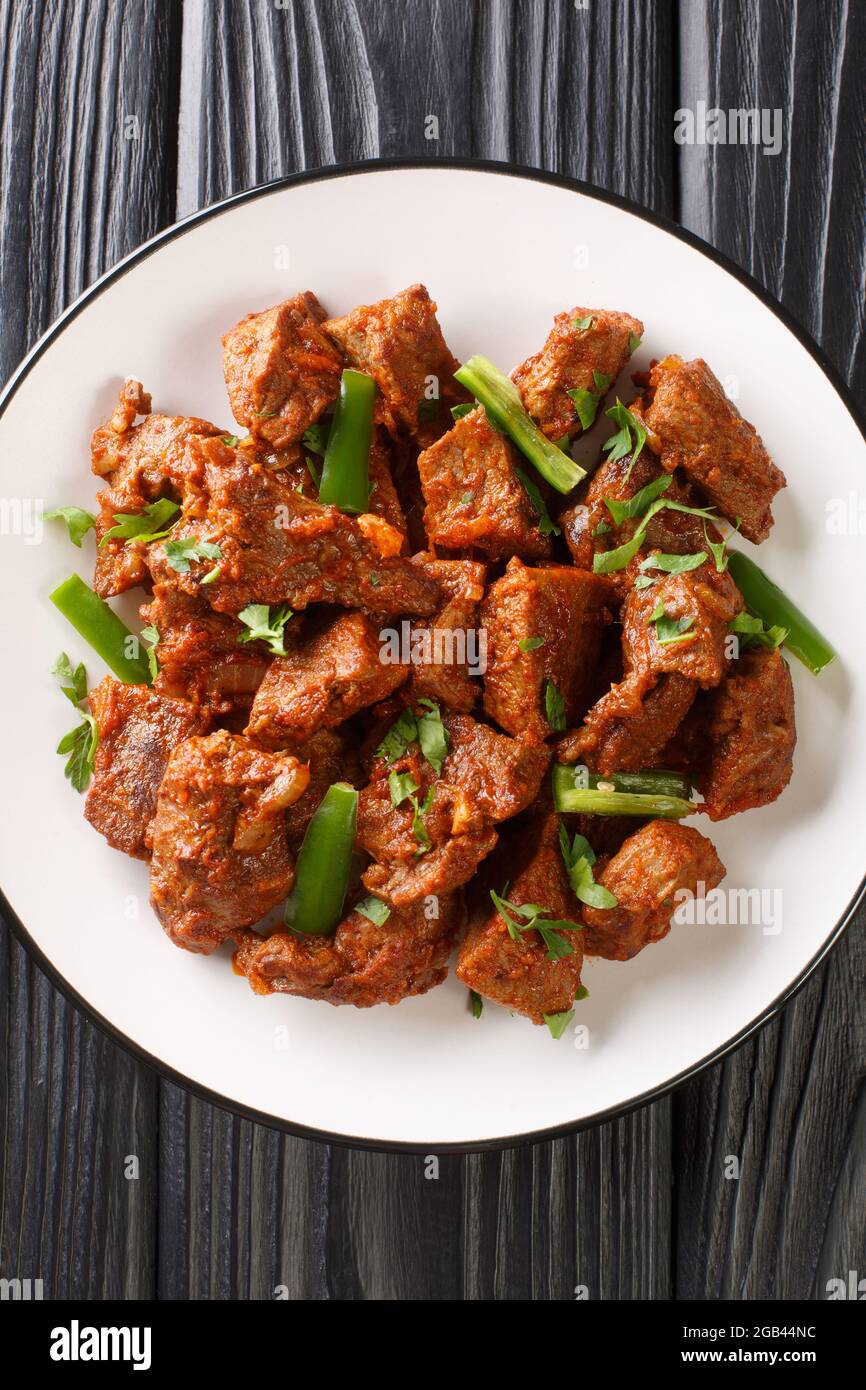 Tibs est un plat éthiopien populaire de bœuf sauté aromatisé avec le nitre kibbeh et le berbère closeup dans l'assiette sur la table. Vue verticale du dessus de l'abov Banque D'Images