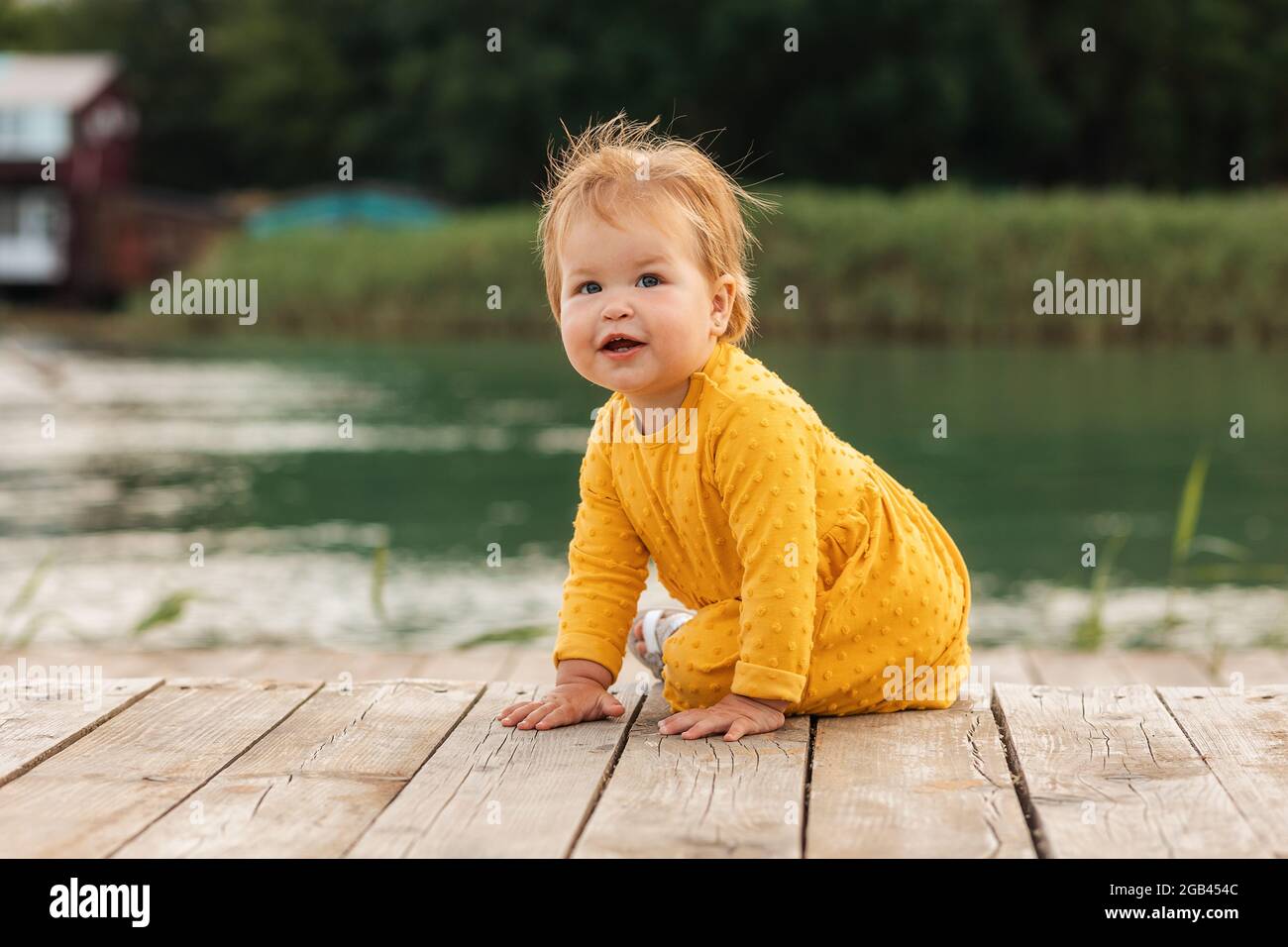 Mignon Caucasien Souriant Enfant Assis Sur La Jetee Au Bord De La Riviere A L Exterieur Le Concept D Une Enfance Heureuse Et De L Autisme D Enfance Photo Stock Alamy