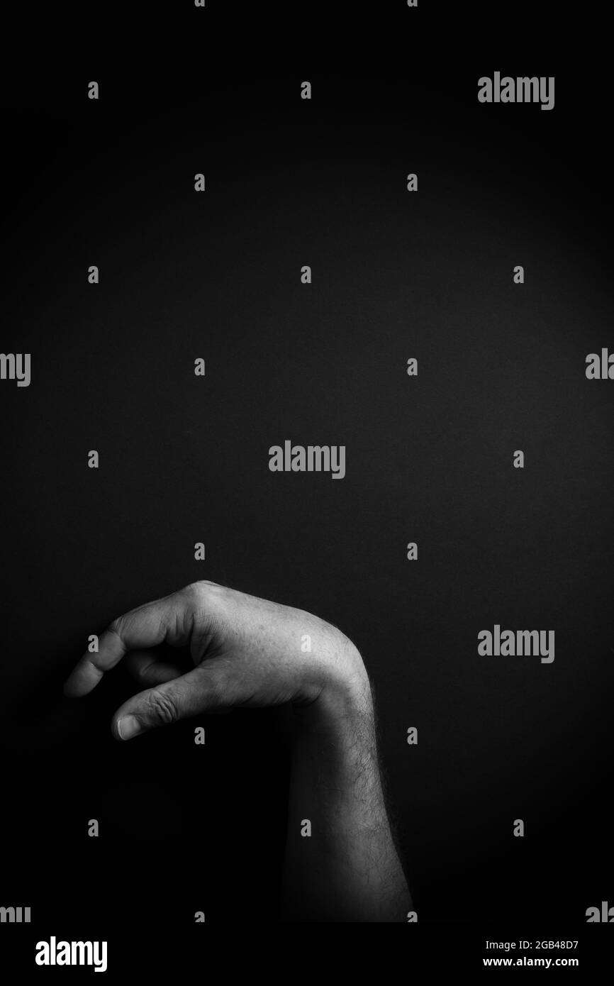 Image B&W dramatique de la main masculine démontrant l'ASL American Sign Language lettre Q avec espace de copie vide pour les éditeurs Banque D'Images