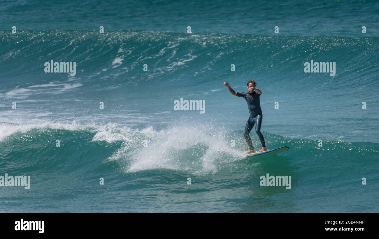 Une action spectaculaire en tant que surfeur fait une vague à Fistral à Newquay, dans Cornwall. Banque D'Images