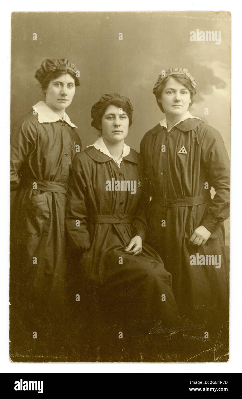 Image originale, nette et claire de la première Guerre mondiale carte postale d'un groupe de travailleuses de munitions attirantes, portant des badges triangulaires du ministère des munitions « sur le service de guerre ». Du studio de Boughtons, Ipswich, Royaume-Uni vers 1916-1918. Banque D'Images