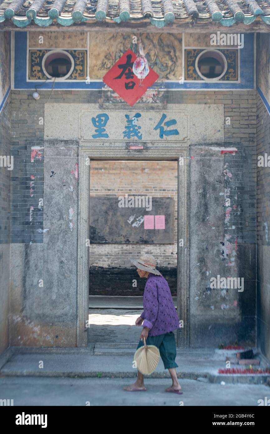Portrait d'une vieille dame marchant dans un village chinois Banque D'Images