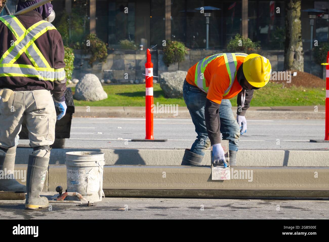 Ouvriers construisant une barrière de ciment sur une route à Coqutlam, B. C., Canada. Banque D'Images