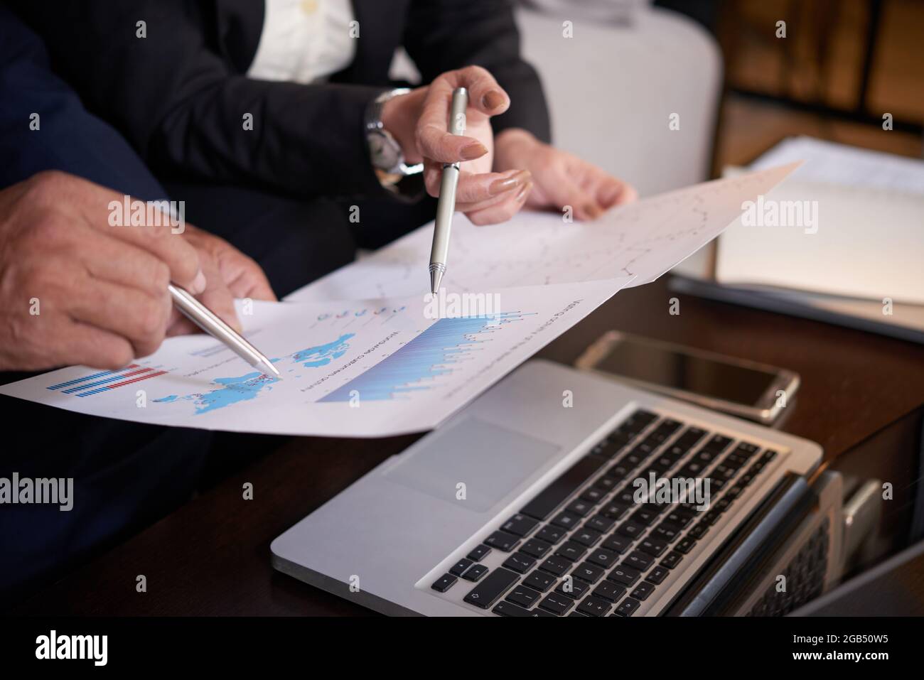 Image rapprochée des professionnels montrant le graphique des ventes lors de la discussion sur le développement de l'entreprise lors d'une réunion Banque D'Images