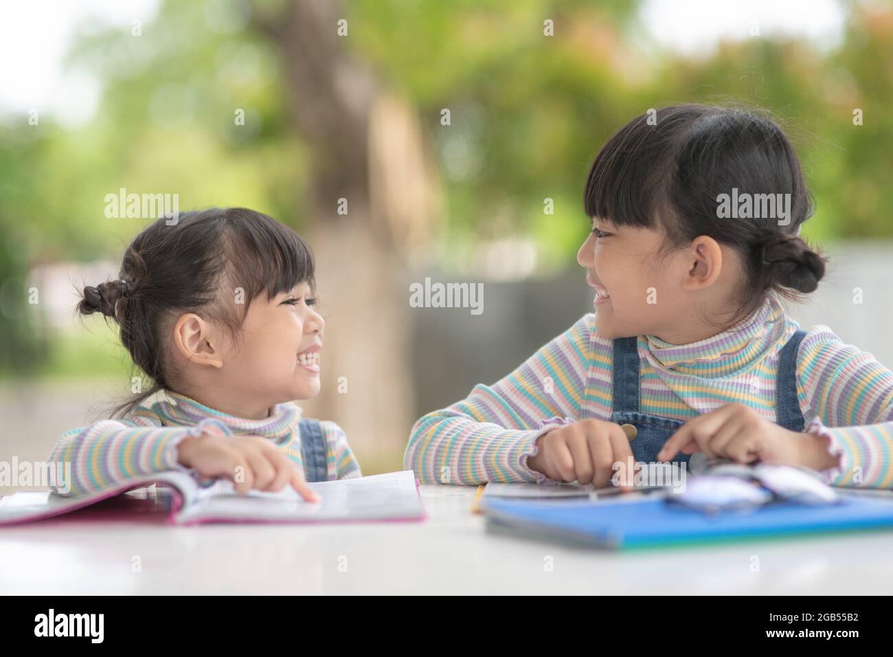 Deux jeunes filles asiatiques qui lisent le livre sur la table Banque D'Images