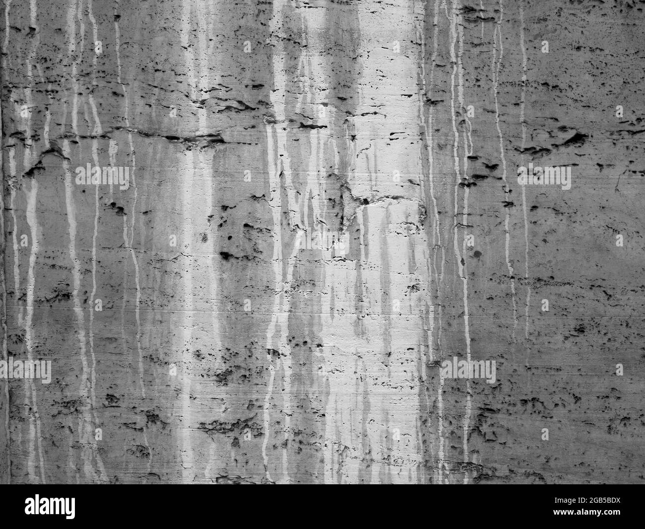 Mur en béton de ciment ruiné et vieilli avec trous et taches d'eau modèle d'arrière-plan texturé Banque D'Images