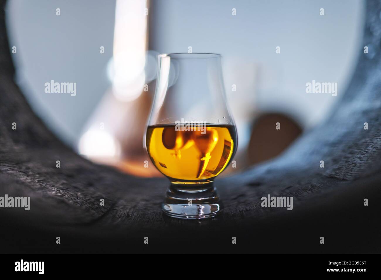 Un verre de whisky dans le vieux tonneau de chêne. Cuivre alambique en arrière-plan. Concept de distillerie d'alcool traditionnelle Banque D'Images