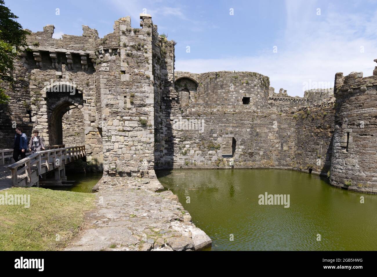 Touristes au château de Beaumaris, murs et douves, château médiéval du XIIIe siècle et site classé au patrimoine mondial de l'UNESCO, Beaumaris, Anglesey Wales UK Banque D'Images