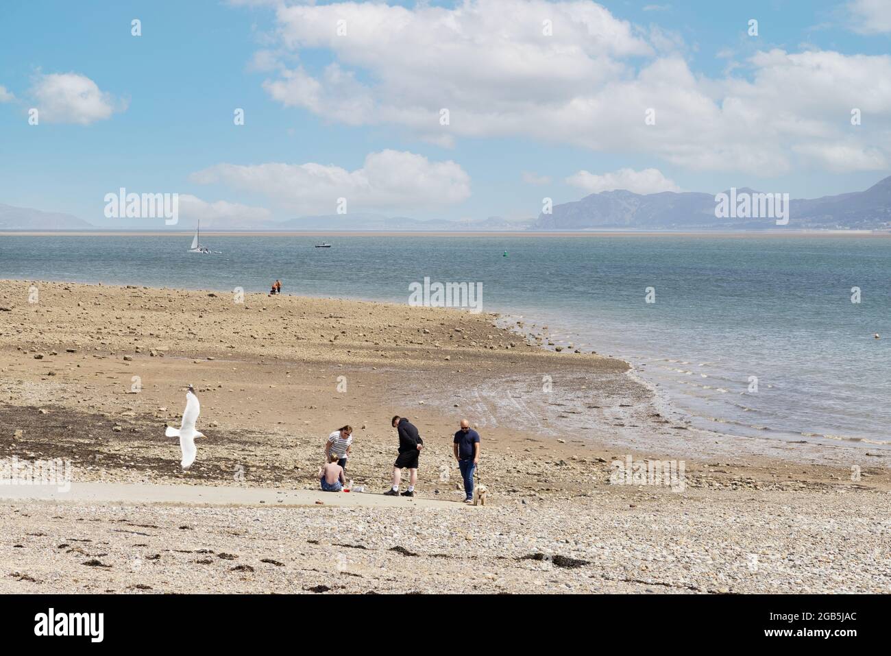 Staycation UK en été; les gens sur la plage, la plage de Beaumaris, le front de mer de Beaumaris, Anglesey Wales Britain Banque D'Images