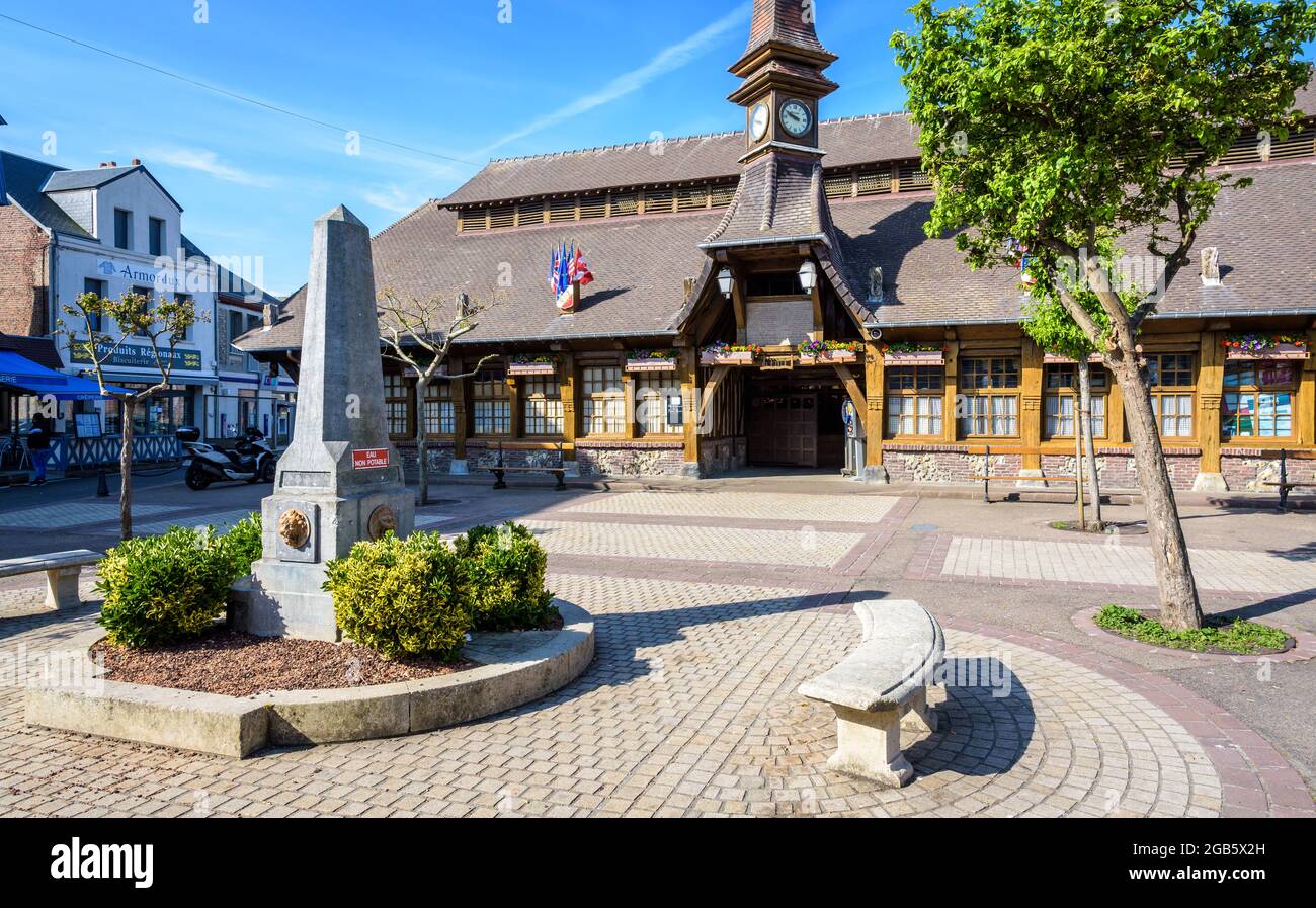 La place Marechal Foch à Etretat, en France, avec le vieux marché, un marché couvert construit en 1927, et une fontaine en forme d'obélisque le matin ensoleillé. Banque D'Images