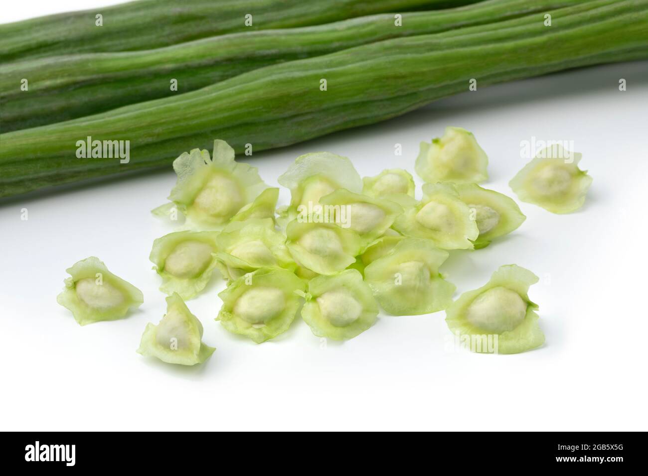 Grains de moringa entiers verts frais et graines isolées sur fond blanc Banque D'Images