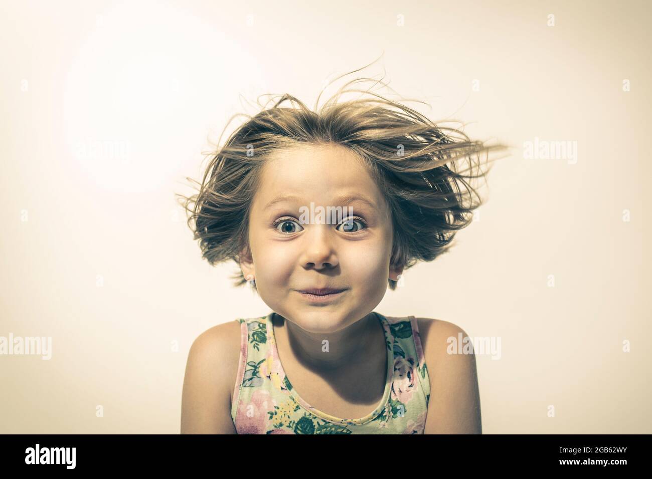petite fille regarde dans l'appareil photo avec l'expression drôle et amusé. studio portrait Banque D'Images