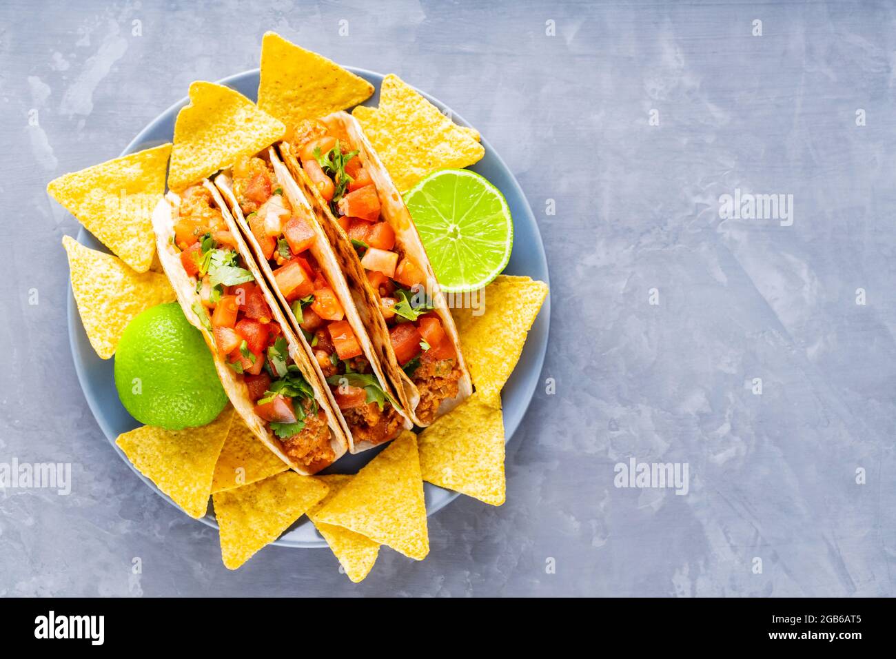 Tacos mexicains et jetons nacho sur une assiette. Tacos et chips tortilla  sur fond gris. Cuisine mexicaine hispanique. Copier l'espace. Pose à plat  Photo Stock - Alamy