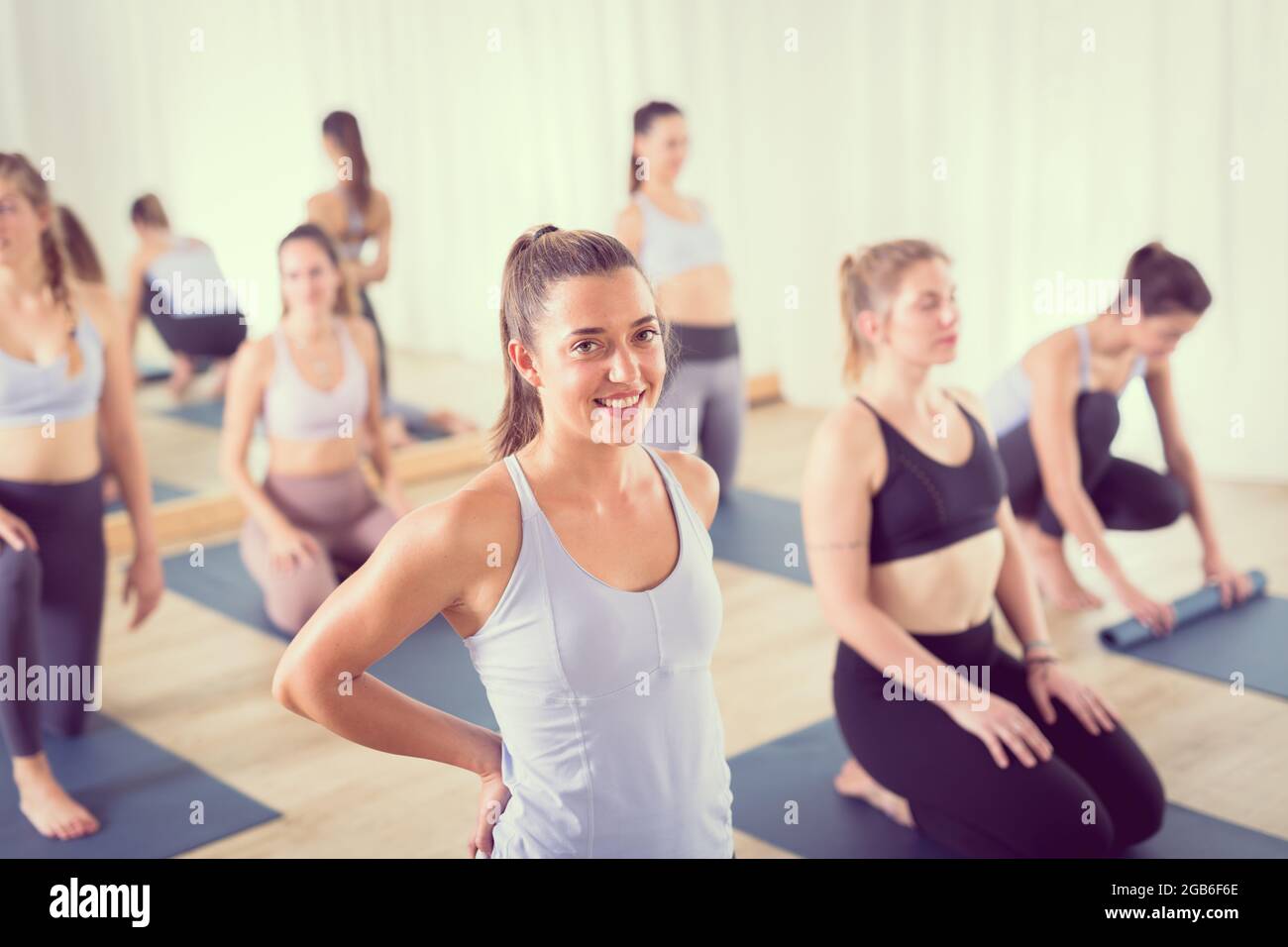 Portrait d'une belle jeune professeur de yoga se détendre après avoir donné à la classe de yoga sportif grand groupe de personnes intéressantes. Vie saine et active Banque D'Images