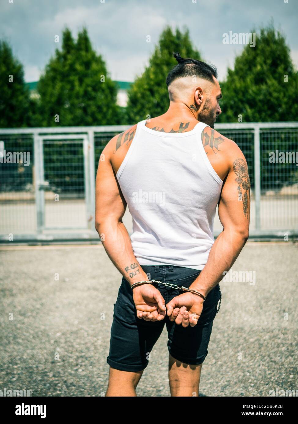 Un jeune homme fort déchirant les menottes dans le parc Banque D'Images