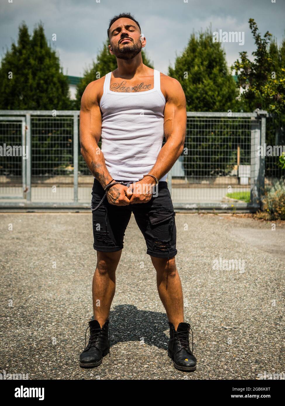 Un jeune homme fort déchirant les menottes dans le parc Banque D'Images