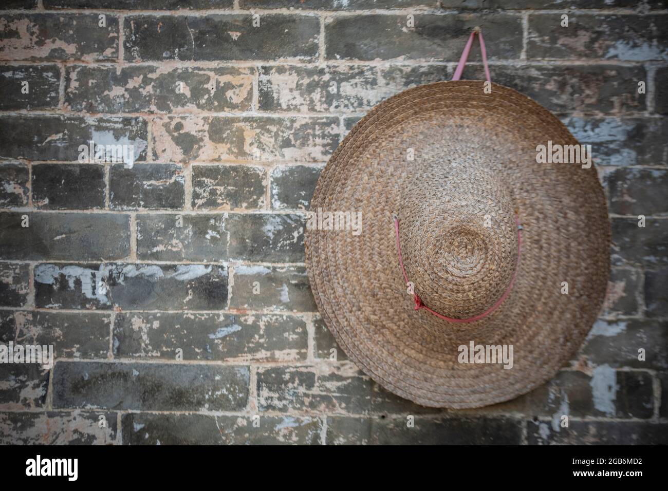 Un chapeau de coterie chinois est accroché à une cheville dans un village en Chine Banque D'Images