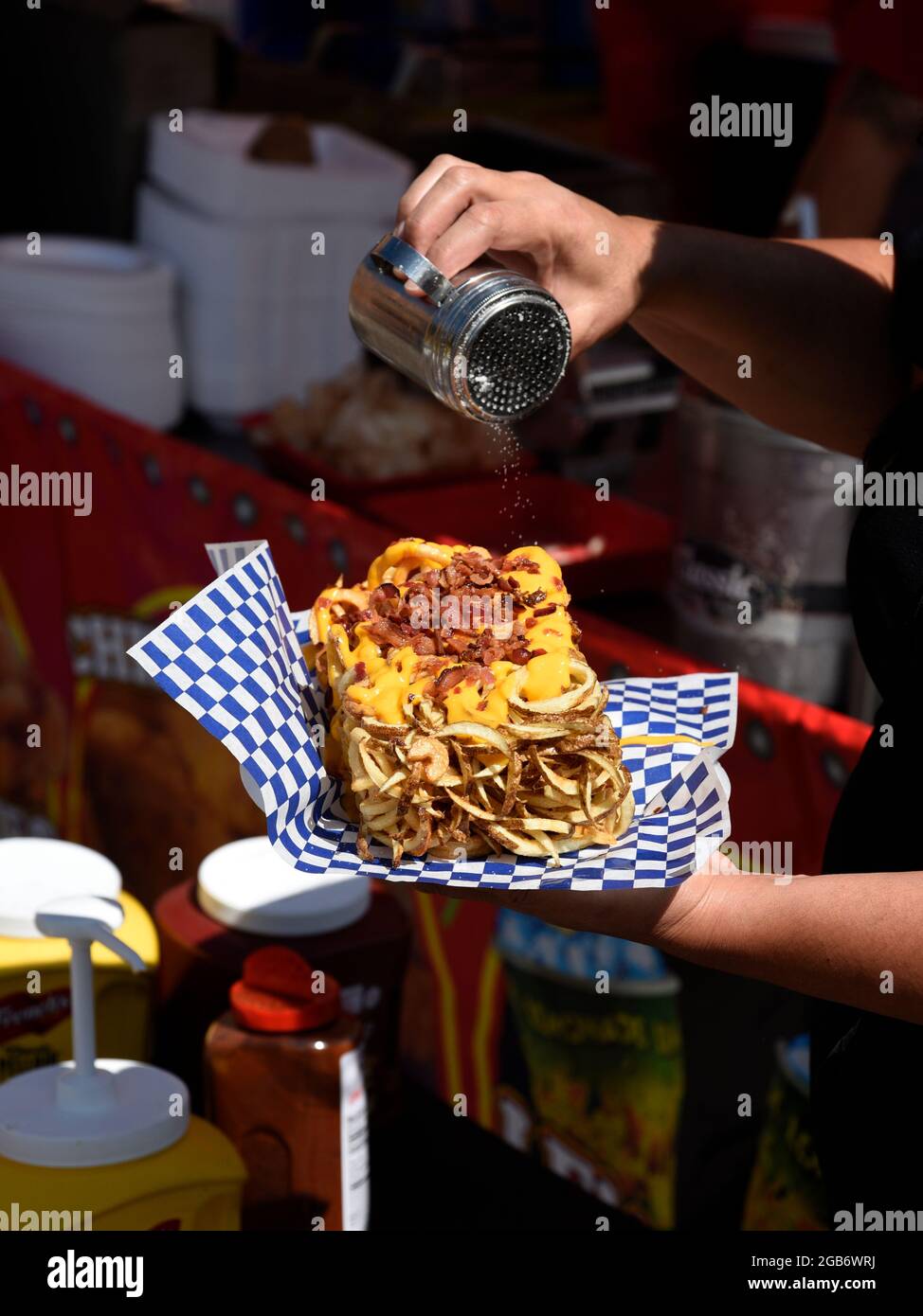 Une femme achète un déjeuner de restauration rapide composé de frites, de fromage et de bacon dans un kiosque à Santa Fe, au Nouveau-Mexique. Banque D'Images