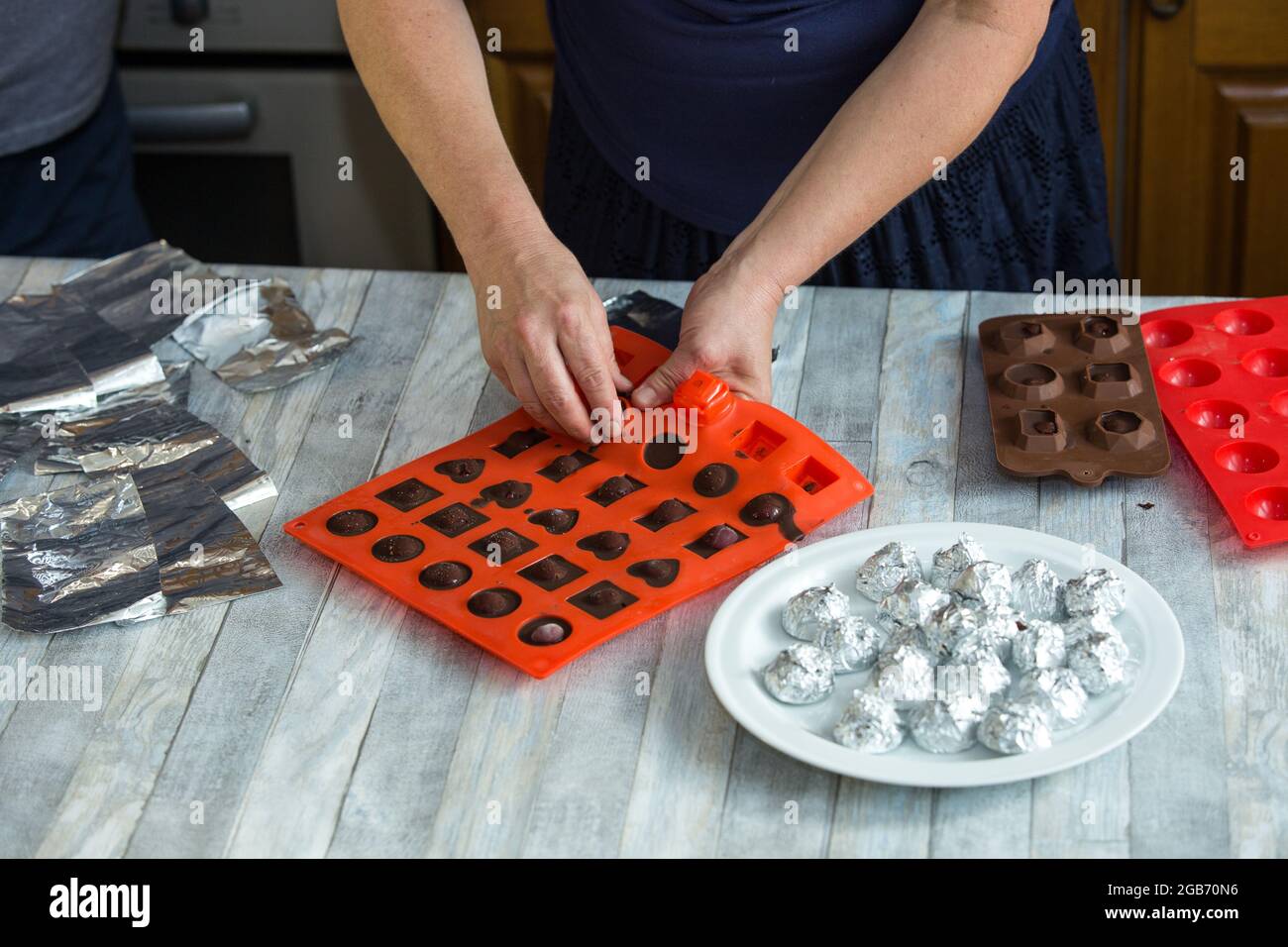 Processus étape par étape de fabrication de chocolats à partir de chocolat noir et de cerises au cognac à la maison. Chaque bonbon est retiré du moule en silicone et emballé Banque D'Images