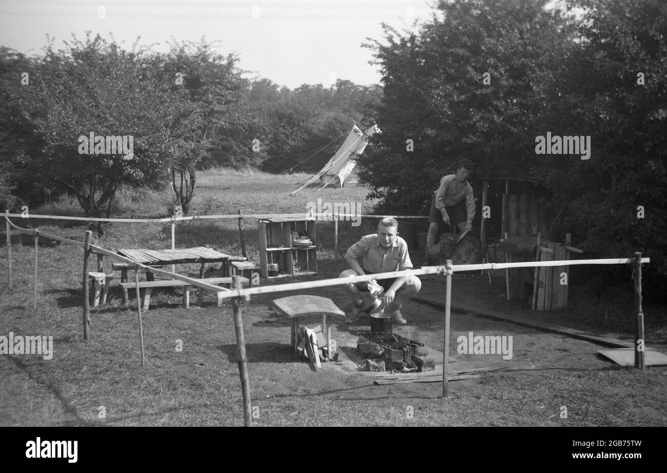 1951, historique, deux maîtres scouts dans la zone de cuisson ou de préparation de nourriture et de restauration au bord du camping, Angleterre, Royaume-Uni. Banque D'Images