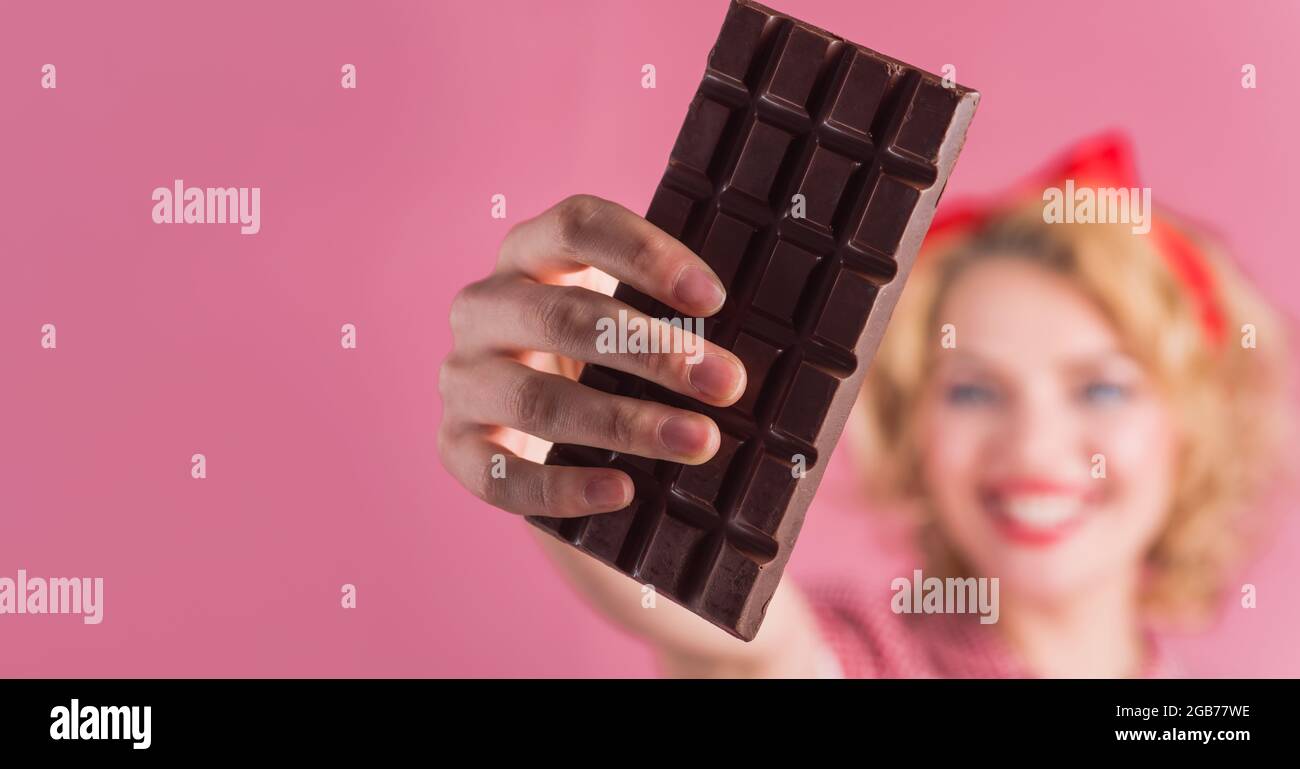 Femme main avec barre de chocolat. Mets sucrés. Espace de copie pour la publicité. Mise au point sélective. Banque D'Images