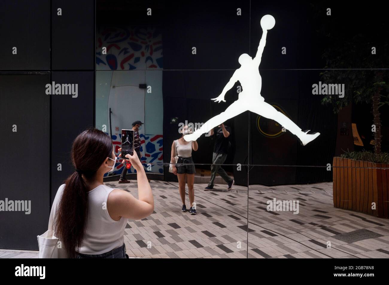 Hong Kong, Chine. 02 août 2021. Une femme prend une photo de la marque américaine de vêtements de sport, produite par Nike, Air Jordan, logo à Hong Kong. (Photo de Budrul Chukrut/SOPA Images/Sipa USA) crédit: SIPA USA/Alay Live News Banque D'Images