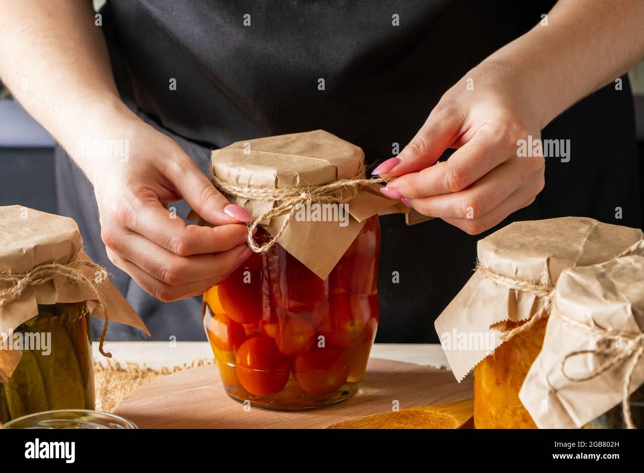 La femme fermente des légumes. Tomates marinées en pots. Préserver la récolte d'automne. Aliments biologiques. Banque D'Images