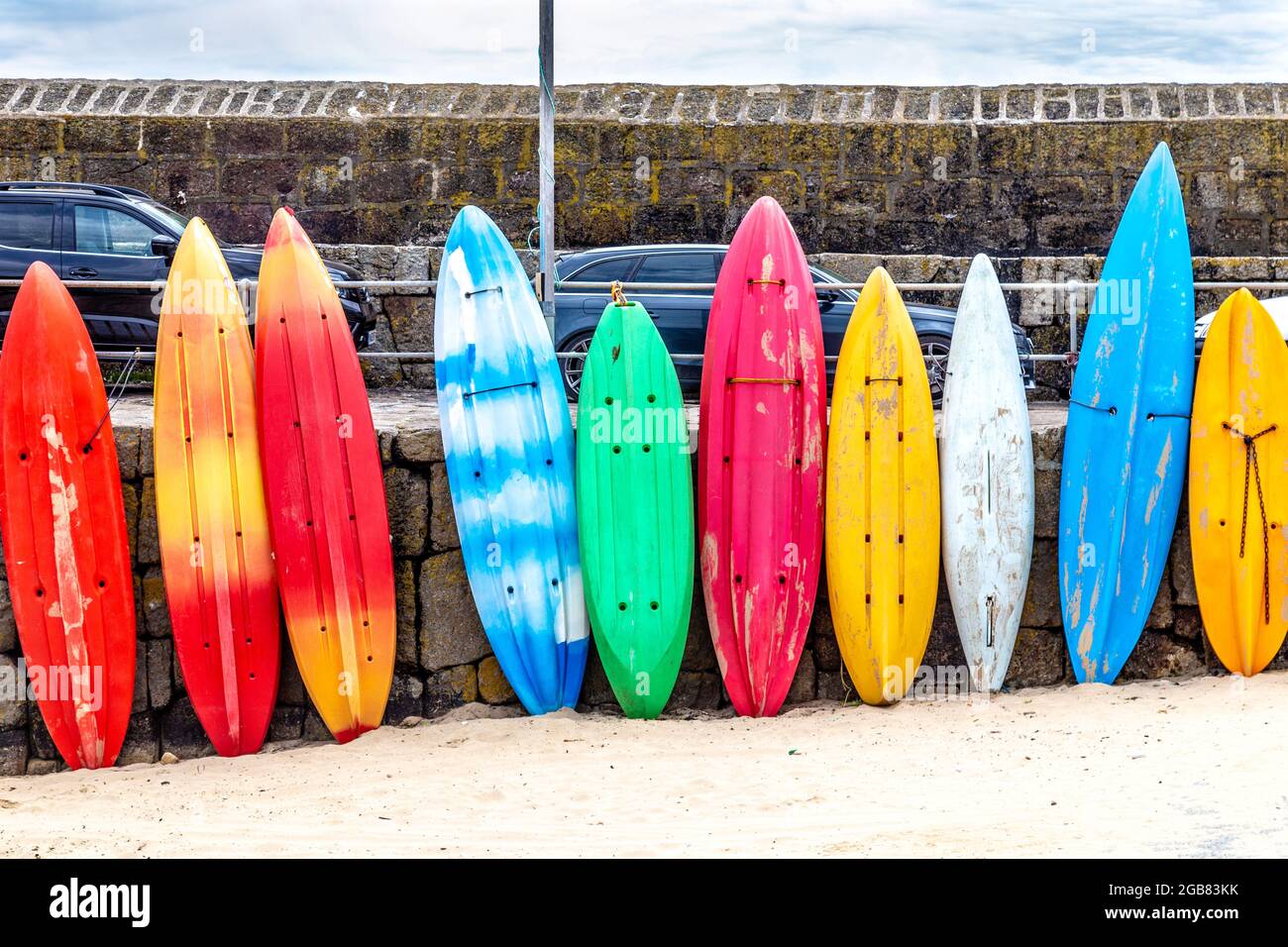 Planches de surf colorées, canoës et kayaks au port de Mousehole, Mousehole, Cornwall, Royaume-Uni Banque D'Images