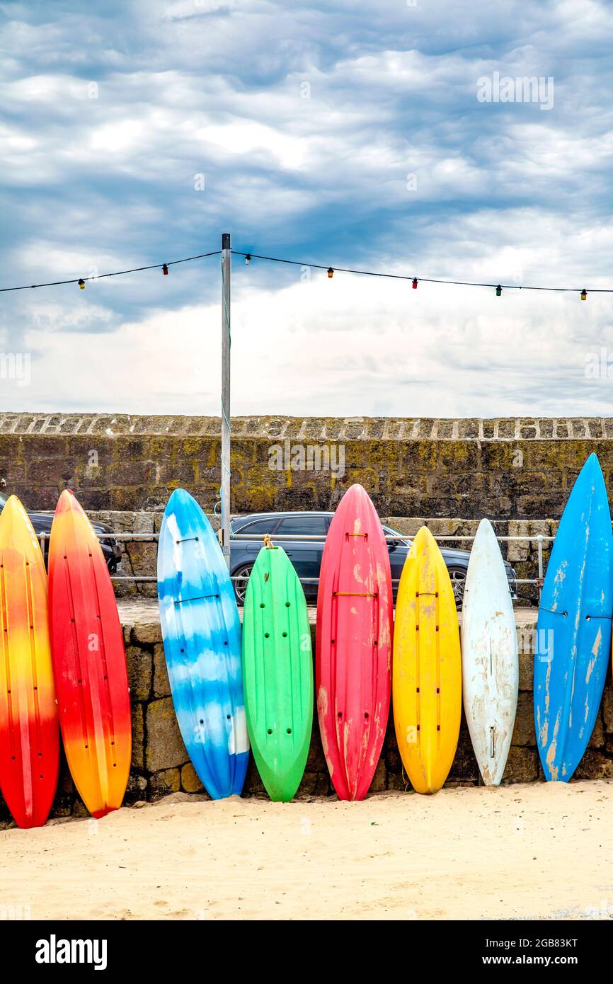 Planches de surf colorées, canoës et kayaks au port de Mousehole, Mousehole, Cornwall, Royaume-Uni Banque D'Images