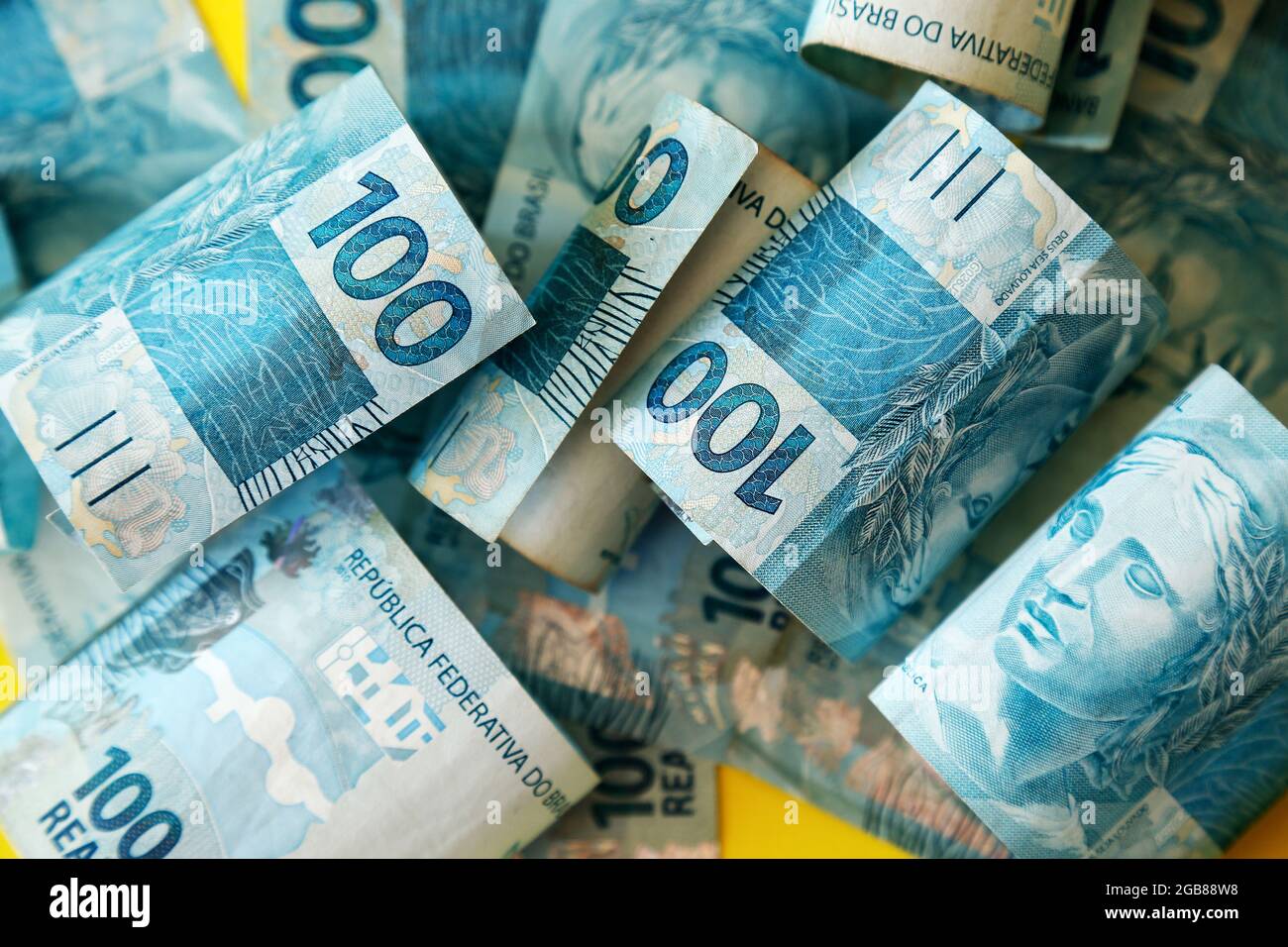 argent du brésil empilé sur la surface jaune - plusieurs centaines des factures réelles Banque D'Images