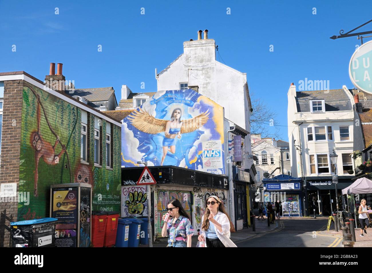 De jeunes filles à la mode se promèquent devant la fresque « Angels » de REQ, une œuvre d'art commandée rendant hommage au NHS et à ses ouvriers, Brighton, Angleterre, Royaume-Uni Banque D'Images