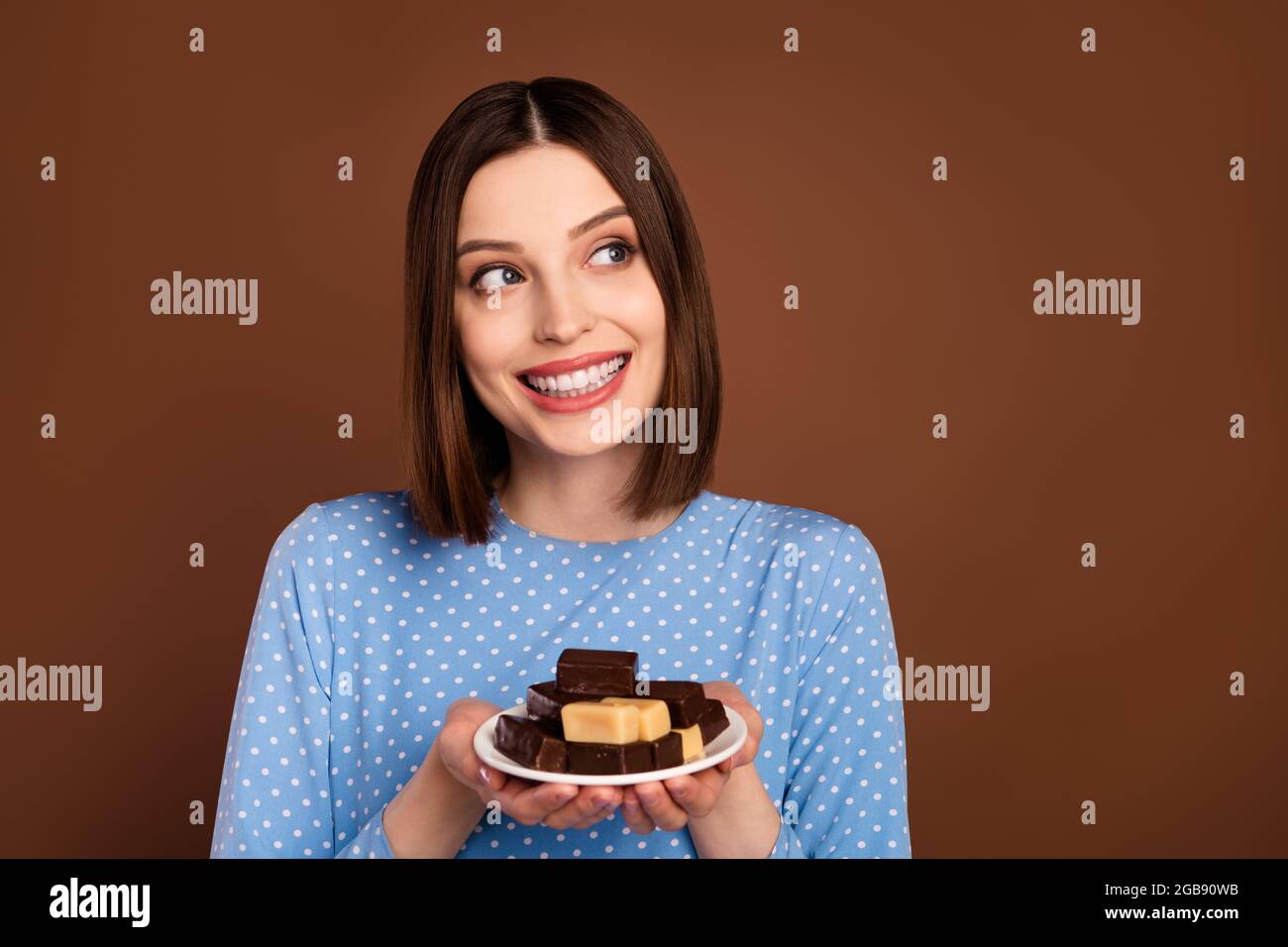 Photo de doux court coiffure femme millénaire tenir chocolat look vide  espace porter blouse bleue isolée sur fond brun couleur Photo Stock - Alamy