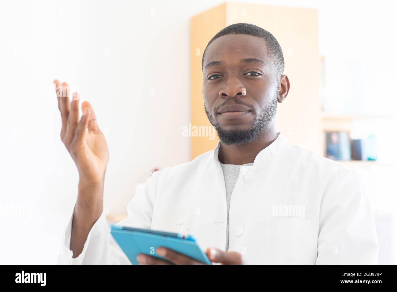 Jeune médecin noir avec une blouse et un comprimé expliquant dans la chirurgie, Freiburg, Bade-Wurtemberg, Allemagne Banque D'Images Jeune médecin noir avec une blouse et un comprimé expliquant dans la chirurgie, Freiburg, Bade-Wurtemberg, Allemagne Banque D'Images