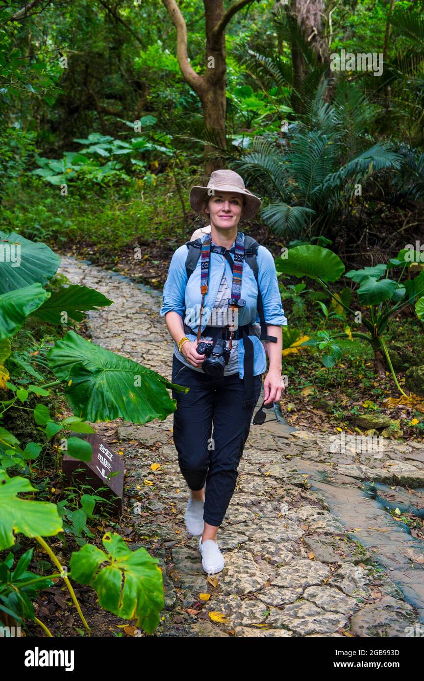 Womna randonnée avec son bébé à travers le site classé au patrimoine mondial de l'UNESCO, site sacré Sefa Utaki, Okinawa, Japon Banque D'Images