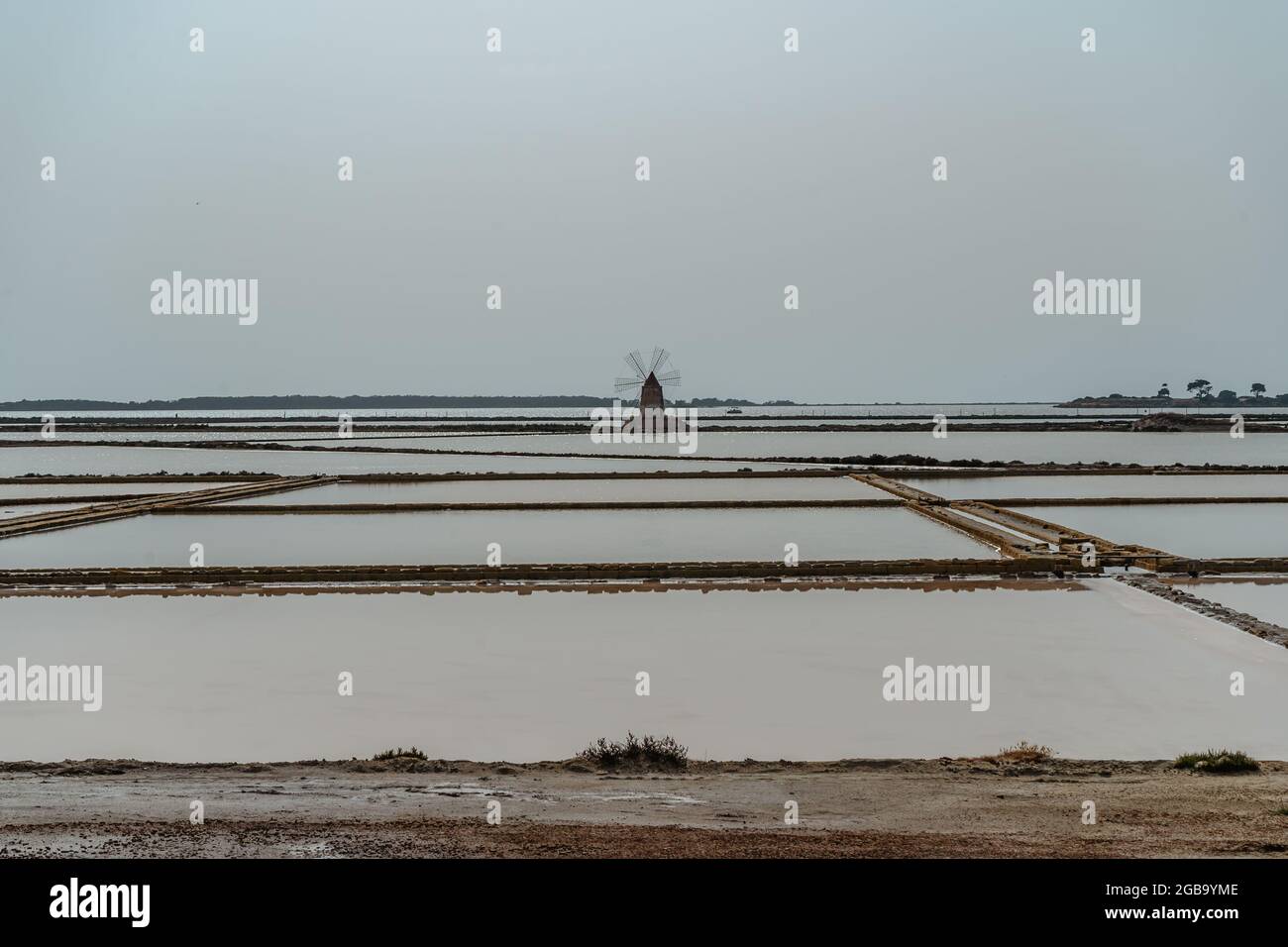 Salin de la Laguna Marsala,Sicile,Italie.Réserve naturelle avec de beaux moulins à vent, piscines saumâtre scintillant avec différentes couleurs, production traditionnelle Banque D'Images