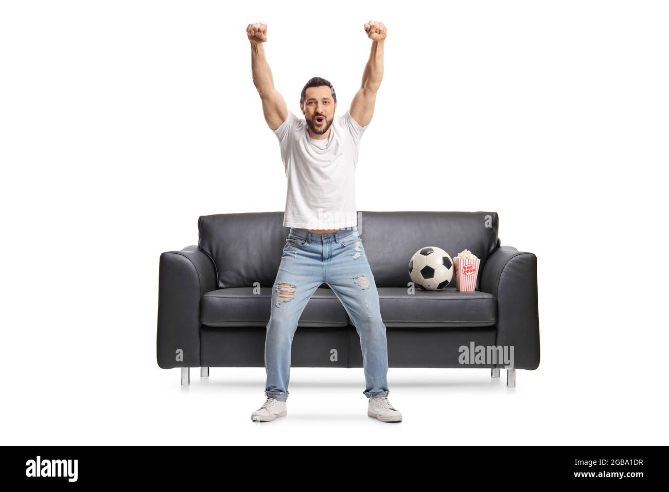 Portrait complet d'un jeune homme heureux qui applaudisse avec un football sur un canapé isolé sur fond blanc Banque D'Images