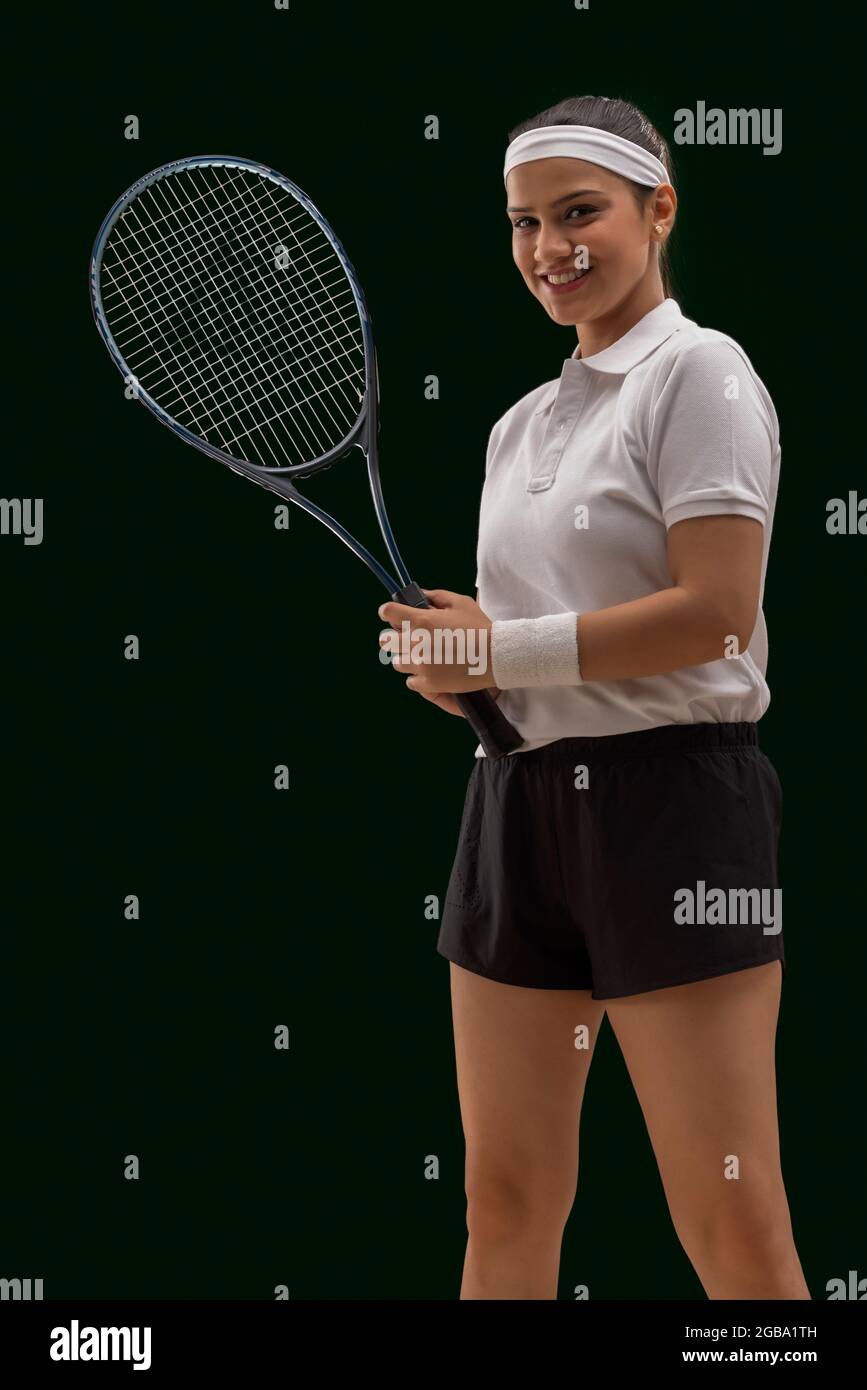 UN JOUEUR DE TENNIS HEUREUX DEBOUT DEVANT L'APPAREIL PHOTO AVEC RAQUETTE Banque D'Images