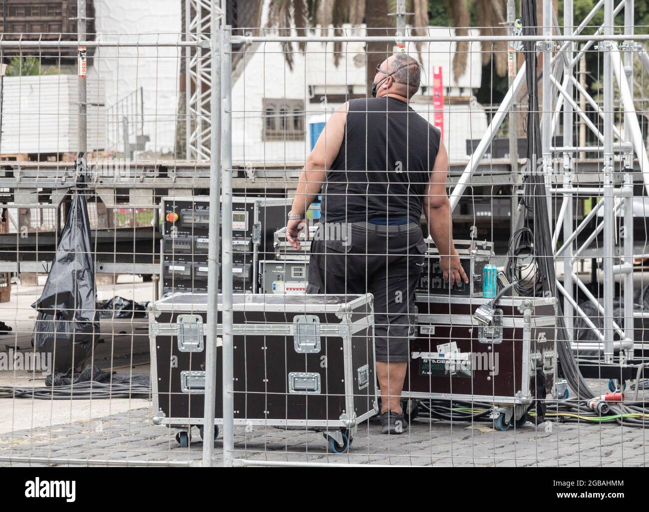 Vue arrière du roadie portant un masque facial lors d'un concert en plein air. Banque D'Images