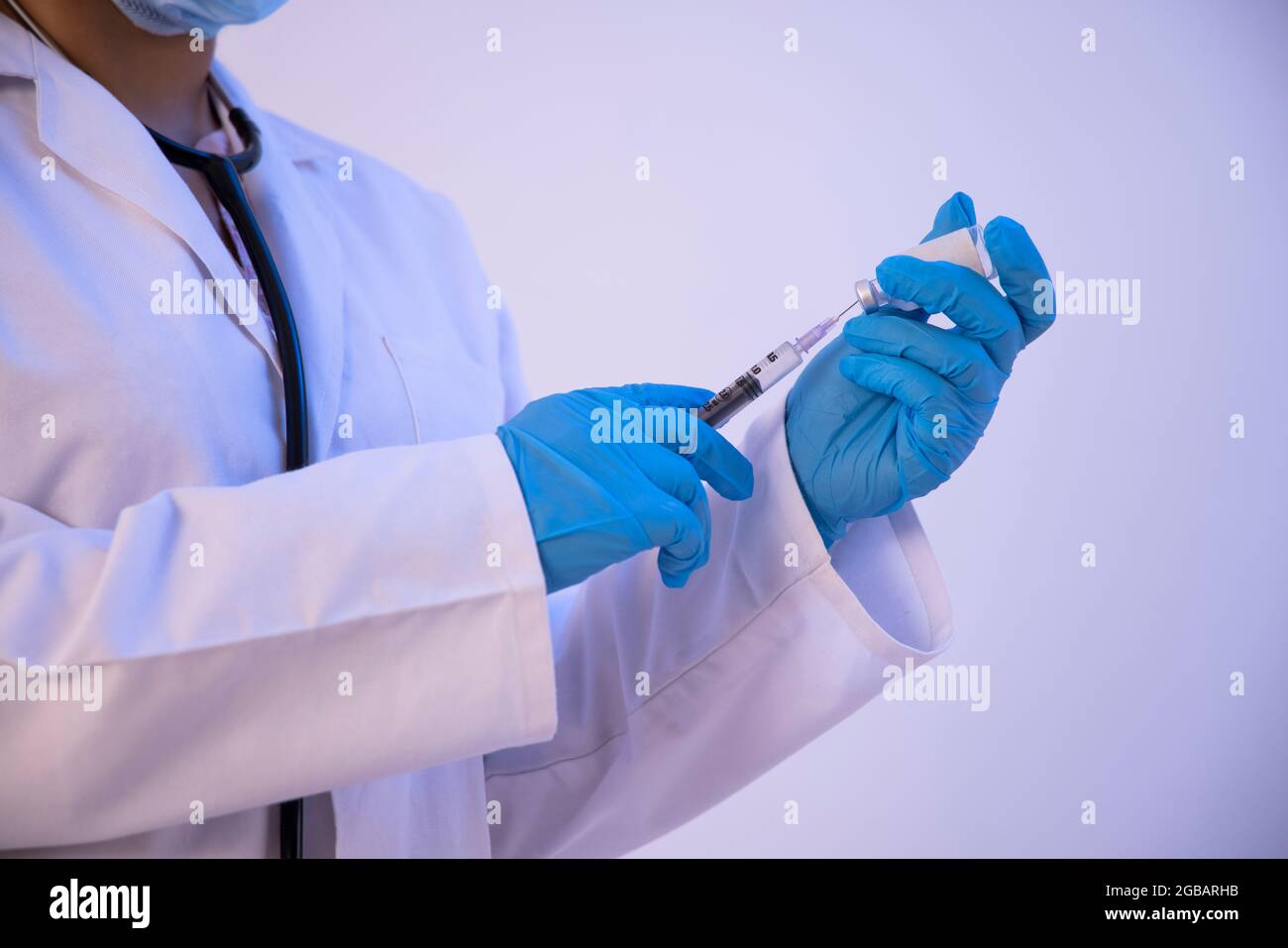 Un médecin remplissant une seringue de la bouteille pour la vaccination. Banque D'Images