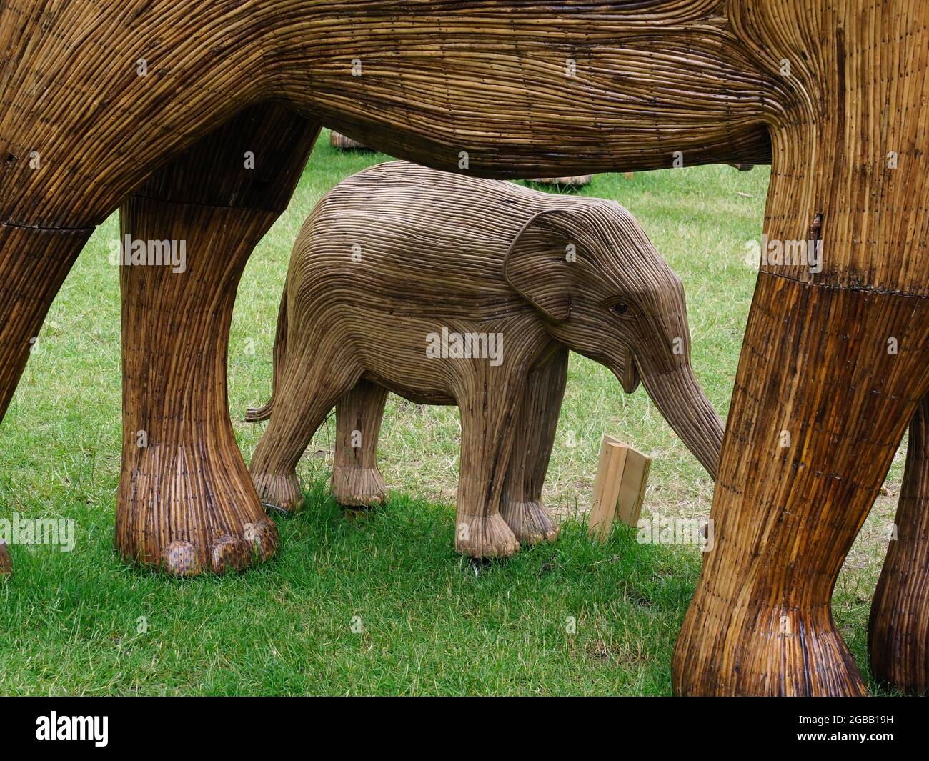 Sculpture d'éléphant de bébé abritant sous un adulte Banque D'Images