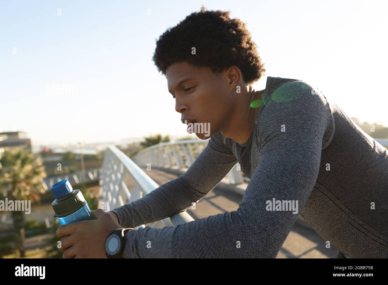 FIT afro-américain homme s'exerçant dans la ville de repos et de l'eau potable Banque D'Images