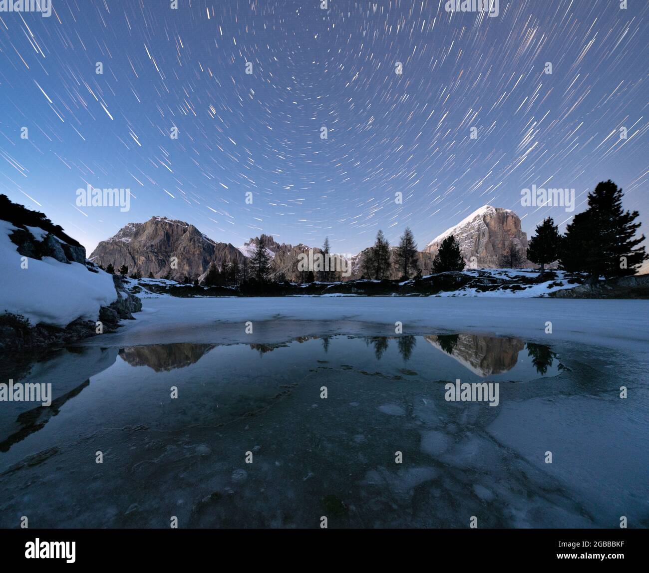 Sentier des étoiles polaires dans le ciel nocturne au-dessus des sommets de Lagazuoi et Tofana di Rozes du lac gelé Limides, Dolomites, Vénétie, Italie, Europe Banque D'Images