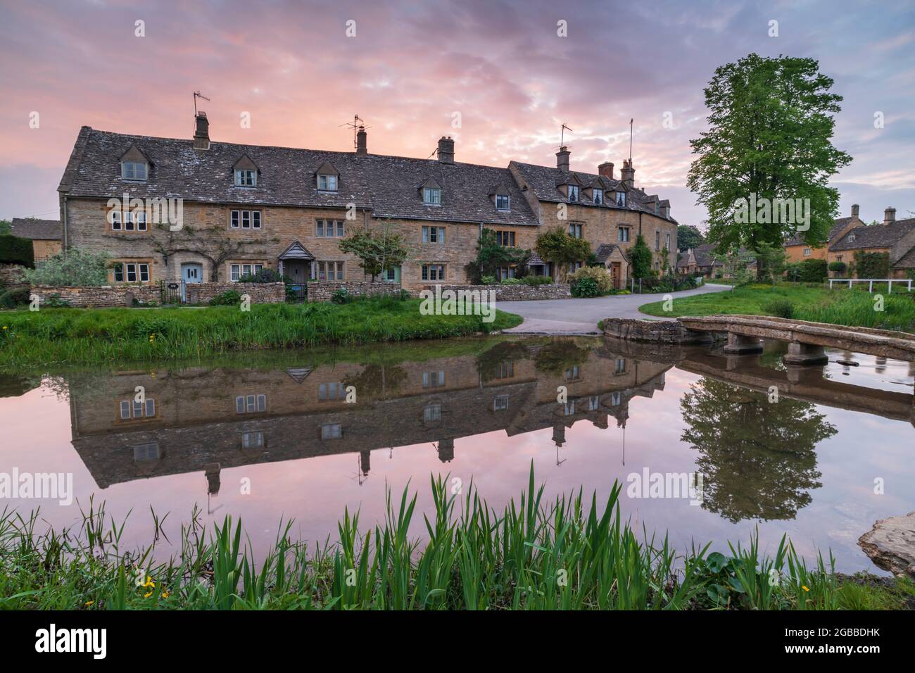 Jolies cottages des Cotswolds reflétés dans le River Eye à l'aube au printemps dans le village de Lower Slaughter, Gloucestershire, Angleterre, Royaume-Uni Banque D'Images