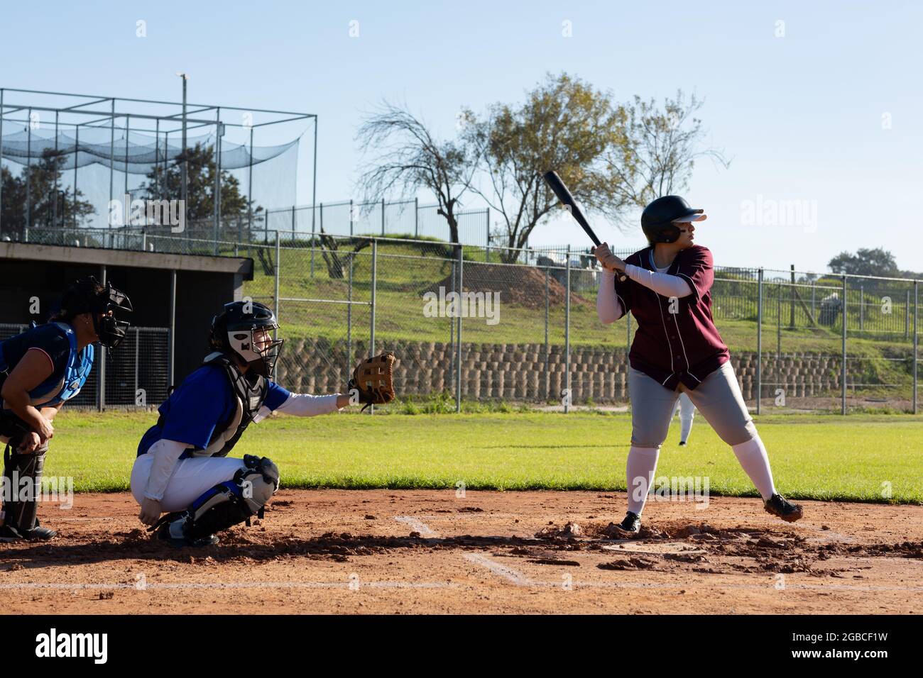 Divers groupes de joueuses de baseball en action sur un terrain de baseball ensoleillé pendant le match Banque D'Images