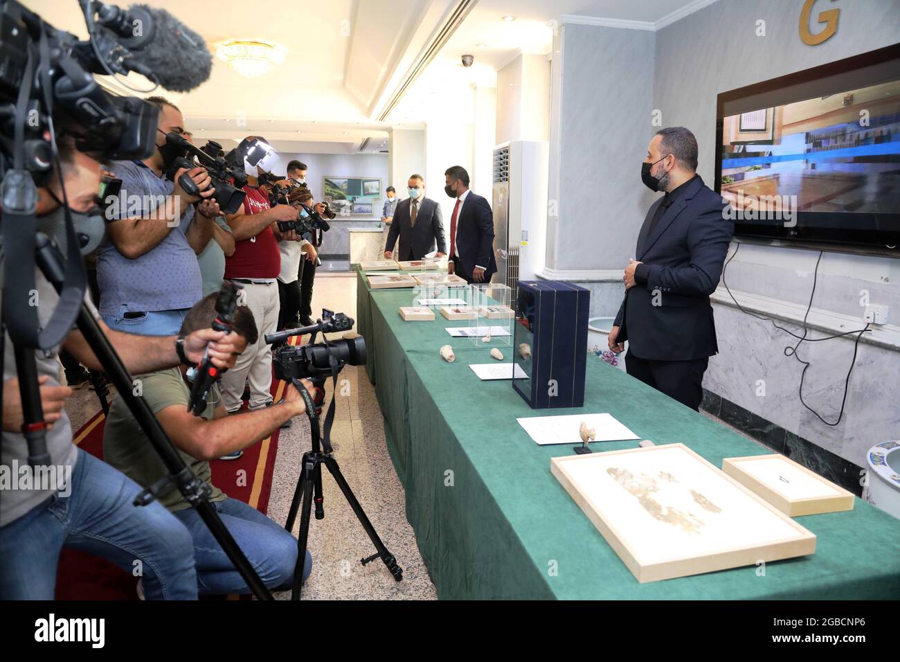(210803) -- BAGDAD, le 3 août 2021 (Xinhua) -- le personnel des médias couvre les objets pillés au Ministère iraquien des affaires étrangères à Bagdad, en Iraq, le 3 août 2021. L'Iraq a reçu quelque 17,000 objets pillés des États-Unis, ce qui marque le retour de la plus grande quantité d'antiquités irakiennes passes. (Xinhua/Khalil Dawood) Banque D'Images