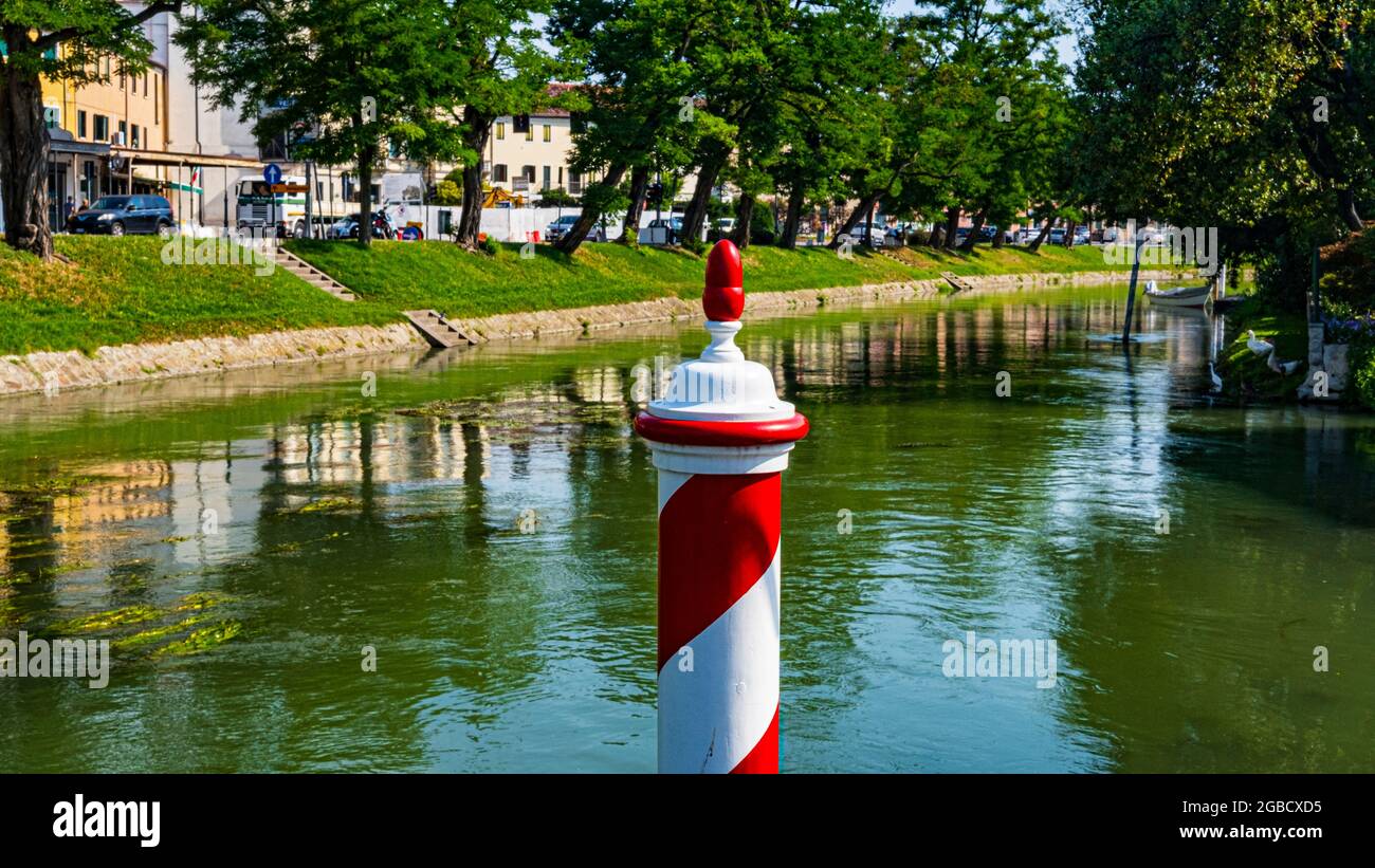 Vue sur le canal avec pôle rouge et blanc à Dolo, Venise, Italie Banque D'Images