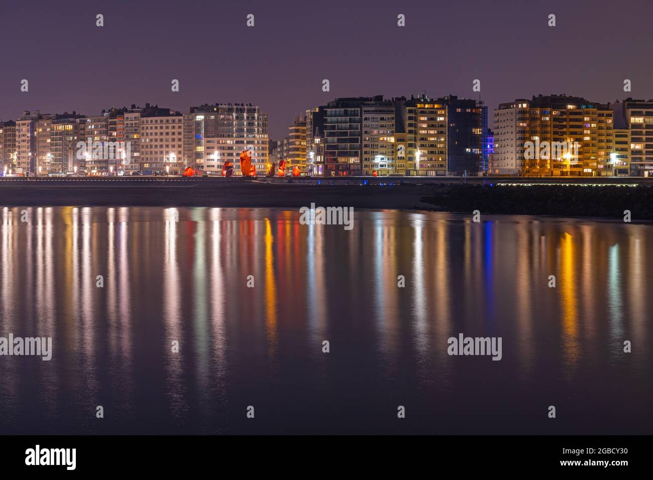 La ville d'Ostende (Oostende) se reflète dans la mer du Nord la nuit, en Belgique. Banque D'Images