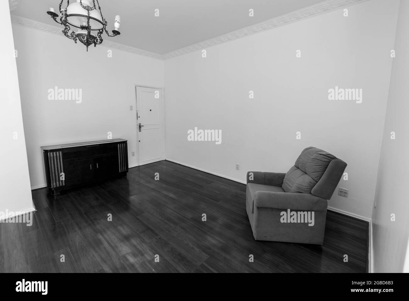 Photo en niveaux de gris du lustre, de la table et de la chaise dans une pièce Banque D'Images